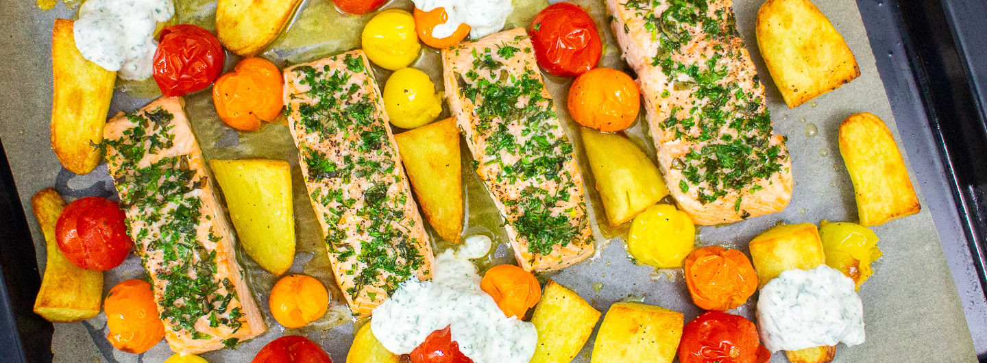 Kräutriger Lachs vom Blech mit Kartoffeln, Kirschtomaten und Kräuterdip